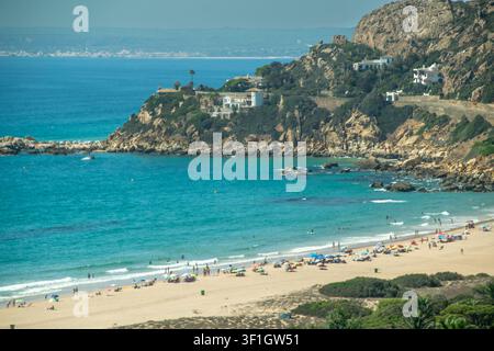 Erhöhte Panoramasicht auf einen sandigen Strand und türkisfarbenes Atlantikwasser entlang der Küste von Cadiz im Süden Spaniens. Stockfoto