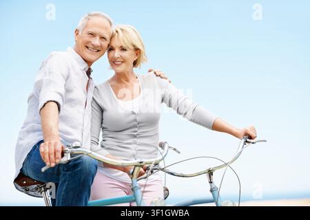 Radfahren, Porträt und Seniorenpaar mit Fahrrad, Liebe und Bindung mit Partner und Reisen zusammen. Glückliche, alte Menschen und Ausflug mit umweltfreundlicher Methode Stockfoto