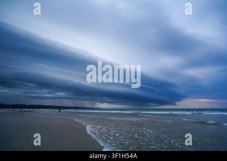 Gewitterwolken über sandigem Strand und Meeresküste Stockfoto