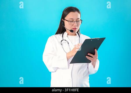 Professionelle junge Ärztin mit Brille, die ein Klemmbrett hält Stockfoto