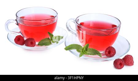 Aromatischer Himbeertee in Glasbechern, frische Beeren und Minze isoliert auf Weiß Stockfoto