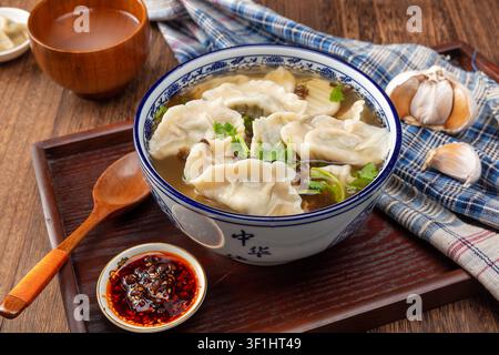 Chinesische Teigtaschen in heißer und saurer Suppe mit Chili-Öl und Koriander Stockfoto