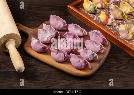 Handgemachte mehrfarbige Gemüsepelmeni vor dem Kochen, roher Dim Sum Stockfoto