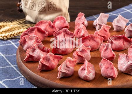 Handgemachte mehrfarbige Gemüsepelmeni vor dem Kochen, roher Dim Sum Stockfoto