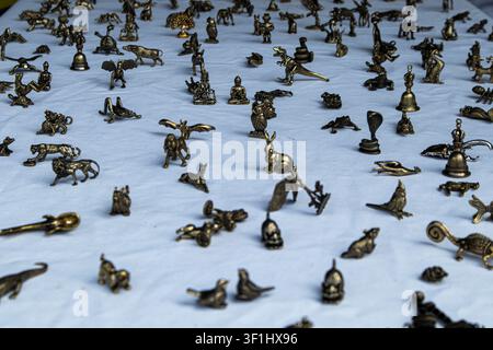 XALO, SPANIEN – 20. JUNI 2026. Eine große Anzahl kleiner Bronze- und Messingfiguren von Tieren und mythischen Kreaturen sind auf einer weißen Tischdecke platziert. Peo Stockfoto