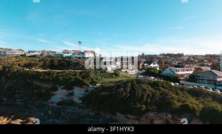 Luftaufnahme des Küstenwohngebiets mit Häusern, die auf dem Hügel thronen und die felsige Küstenlinie und üppige Grünflächen in Dee Why, New South Wales überblicken Stockfoto