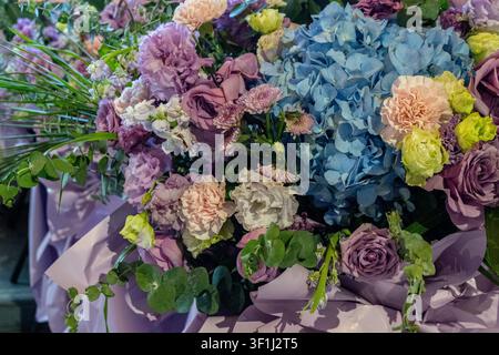 Farbenfrohes Bouquet gemischter Blumen vor unscharfem Hintergrund. Stockfoto