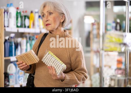 Eine Frau, die sich im Laden eine Wäschespanne ausgesucht hat Stockfoto