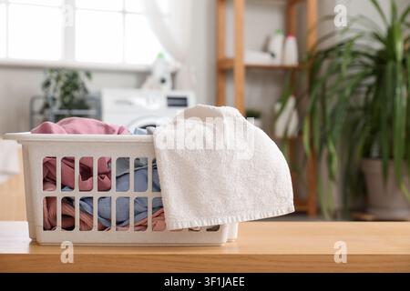 Korb mit Wäsche auf Holztablett im Raum Stockfoto