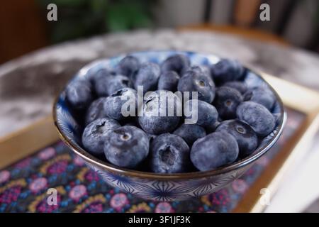 Frische Blaubeeren in einer Schüssel auf einem Holztisch Stockfoto