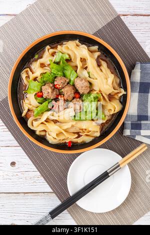 Handgeschnittene Nudeln mit Fleischbällchen, traditionelle chinesische Nudelsuppe Stockfoto