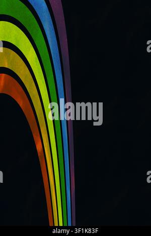 Kreatives Stolz-Rainbow-Konzept mit stilisierten vertikalen Farbbändern auf einem dunklen texturierten künstlerischen Hintergrund mit reichlich schwarzem Negativraum Stockfoto