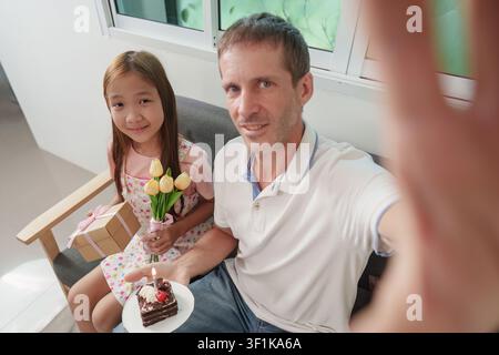 Vater und Tochter nehmen ein Selfie während der Geburtstagsfeier zu Hause Stockfoto