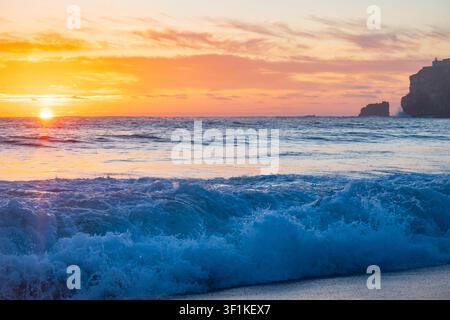 Aufgehende Sonne über dem Meer in der Kleinstadt Nazaré in Portugal, weites Panorama Stockfoto