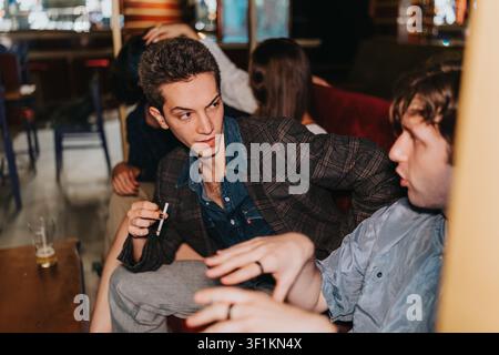 Freunde unterhalten sich bei einem entspannten Abendgespräch in einer Bar-Lounge Stockfoto