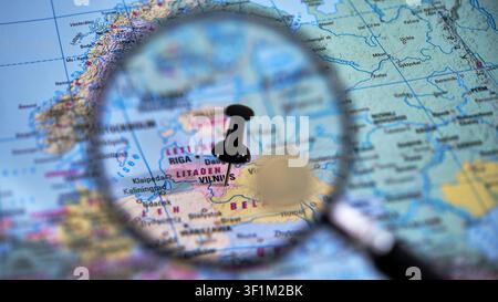 Erkunde Vilnius mit einer Nahaufnahme einer gedruckten Karte und einer Lupe Stockfoto
