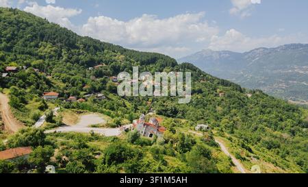 Luftaufnahme aus hohem Winkel der berühmten schiefen Kirche des Dorfes Ropoto in der Nähe von Trikala in Griechenland, die nach einem La auf einem grünen Berghang schräg steht Stockfoto