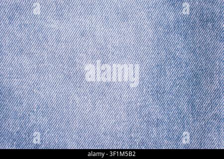 Horizontale Nahaufnahme eines klassischen blauen Jeans-Denimstoffs mit einem deutlichen diagonalen Webmuster auf einem robusten, haltbaren Baumwollkleidungsrücken Stockfoto