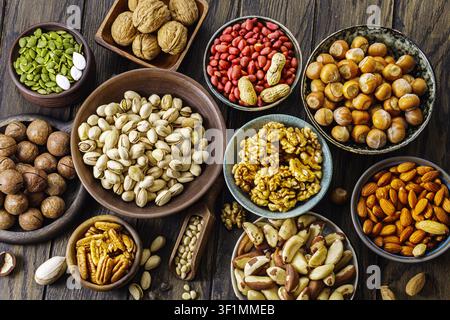 Sortiment an Nüssen, die auf einer Holzoberfläche angeordnet sind und eine visuell ansprechende Darstellung schaffen. Stockfoto