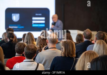 Geschäftspublikum sitzt und konzentriert sich auf den Referenten, Unternehmensseminar mit Netzwerk- und Lernatmosphäre. Stockfoto