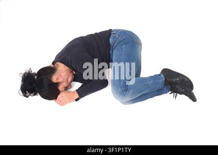 Oberansicht einer Frau, die in der Fötuslage auf dem Boden liegt Stockfoto