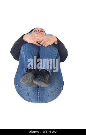 Frau liegt auf dem Boden und hält ihre Beine mit den Armen Stockfoto