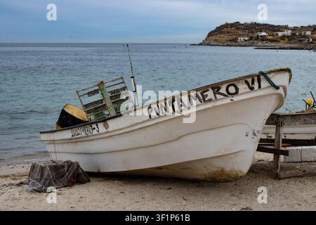 Ein altes Fischerboot liegt an einem abgelegenen Strand weit abseits der Zivilisation Stockfoto