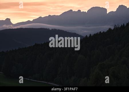 Dolomiten Sonnenaufgang Nahaufnahme mit tiefen Wolken und Waldhügeln Stockfoto
