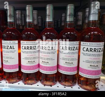 DENIA, SPANIEN - 17. Juli 2025. Rosa Weinflaschen sind ordentlich in einem Regal eines Carrefour-Supermarkts in Spanien angeordnet. Kunden durchstöbern den Laden Stockfoto