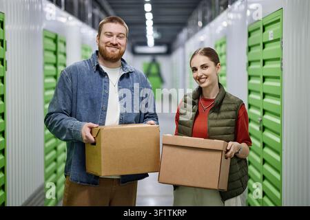 Porträt eines erwachsenen Paares, das Kisten in einer Selbstlageranlage hält Stockfoto