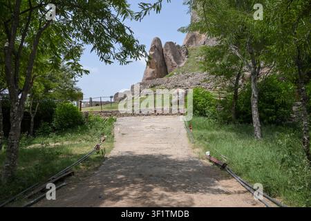 Friedlicher baumgesäumter Pfad durch Heritage-Monument-Landschaften Stockfoto