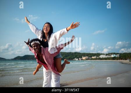 Reines Glück. Ein junges, vielseitiges, multiethnisches Paar genießt jeden Moment ihres tropischen Urlaubs Stockfoto