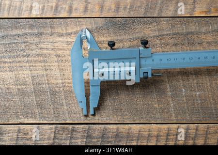 Schnellspannzirkel, ein Präzisionslängenmessgerät auf einem Arbeitstisch aus Holz. Der Schnellspannzirkel ist ein hochgenaues Messgerät. Die exakte Größe des Par Stockfoto
