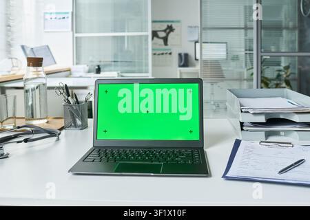 Laptop zeigt Green-Screen-Mockup auf dem Bürotisch für Branding Stockfoto