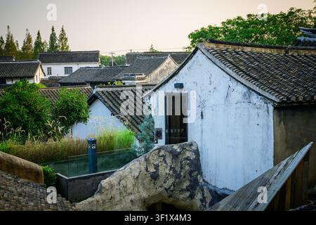 Traditionelle weiße Gebäude mit Ziegeldächern in einer asiatischen Dorfkulisse. Stockfoto