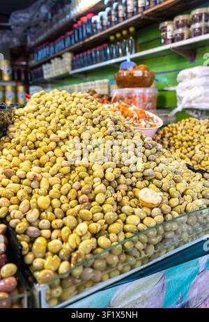 Gestapelte eingelegte Oliven, fermentierte Oliven, mariniertes mediterranes Snack, große Stapel von Olivenessigen auf dem Straßenmarkt, marokkanisches Essen Stockfoto