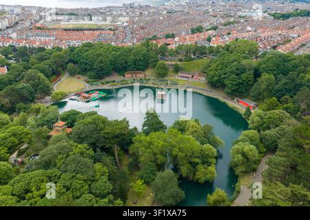 Luftaufnahme von Peasholm Park in Scarborough mit Blick auf den Bootssee, umgeben von Drachenboot-Landschaften, Gärten und Wald sowie dem historischen Meer Stockfoto