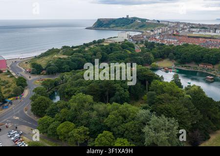 Luftbild von Peasholm Park und Scarborough Castle mit Blick auf die Nordsee, den Bootsee im Wald und der historischen Küstenstadt in North Yorkshire Stockfoto