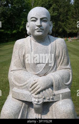 Eine Statue von Subhuti Theraone, einem der 10 Jünger des Buddha. Auf einer Steinstatue am Weg zum Eingang des Chuang Yen Klosters in Carmel NY Stockfoto
