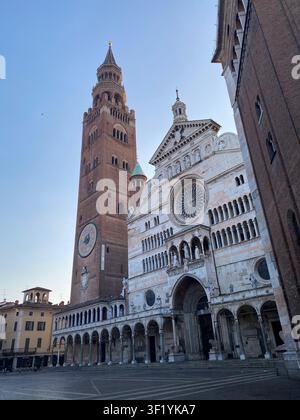 Der Dom von Cremona und der Torrazzo-Glockenturm präsentieren eine dramatische architektonische Präsenz auf der Piazza del Comune unter einem klaren Himmel, verkörpern den reichen Geschich Stockfoto