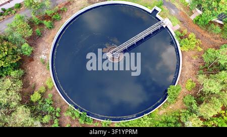 Vertikale Drohnenansicht eines großen runden Sedimentationsbeckens mit Wasserreflexion Stockfoto