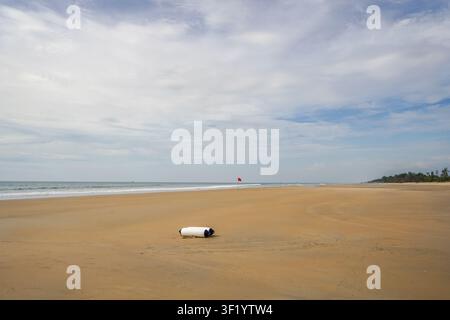 Breiter leerer tropischer Strand unter bewölktem blauem Himmel Stockfoto