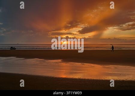 Oranger Sonnenuntergang über tropischer Küstenlinie und ruhigem Ozean Stockfoto