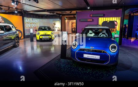Ikoniisches Modernes Mini Cooper Auto fährt auf einer malerischen Stadtstraße Stockfoto
