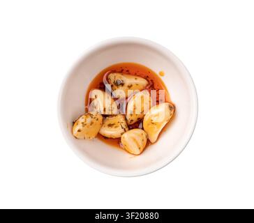 Eingelagerter Knoblauch isoliert, fermentierte Knoblauchzehen mit rotem Chilipfeffer, scharfe Gemüsepickles, Gewürze Knoblauchzehen in Öl und Essig auf weißem Hintergrund Stockfoto