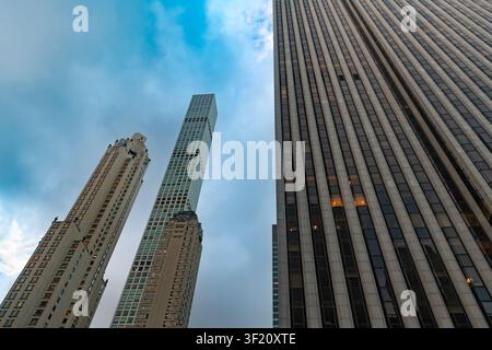 Blick nach oben zu beeindruckenden Wolkenkratzern in Midtown Manhattan bei Tagesanbruch, mit verschiedenen architektonischen Stilen von Hochhäusern in New York City. Stockfoto