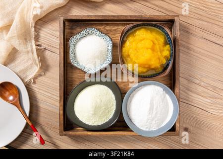 Backzutaten einschließlich Kürbispüree, klebriger Reismehl, Milchpulver und Zucker Stockfoto