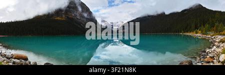 Ein ruhiger Bergsee, der die umliegenden Gipfel und Wolken widerspiegelt. Stockfoto