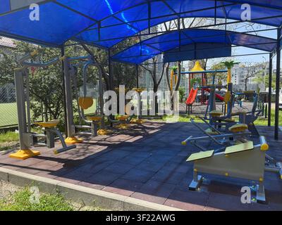 ein Spielplatz mit einem blauen Vordach und einer gelben Rutsche Stockfoto