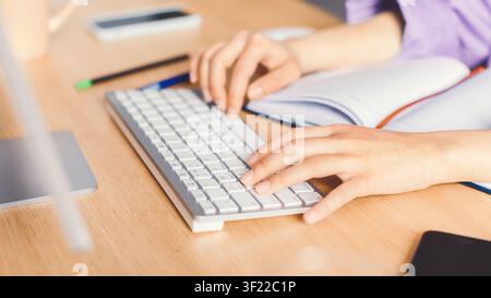 Hände einer jungen Frau, die an einem Standardtastatur am Bürotisch tippt, Geschäftskonzept Stockfoto